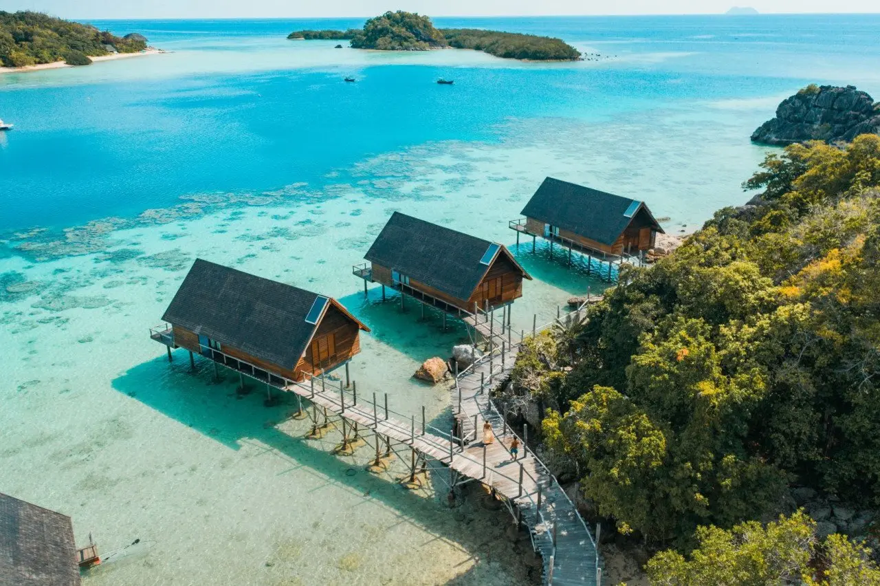 aerial_couple_walking_on_west_overwater_suites_pathway_with_lidi_view