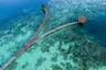 aerial_wooden_jetty_with_thatched_roof_coral_reefs_lagoon