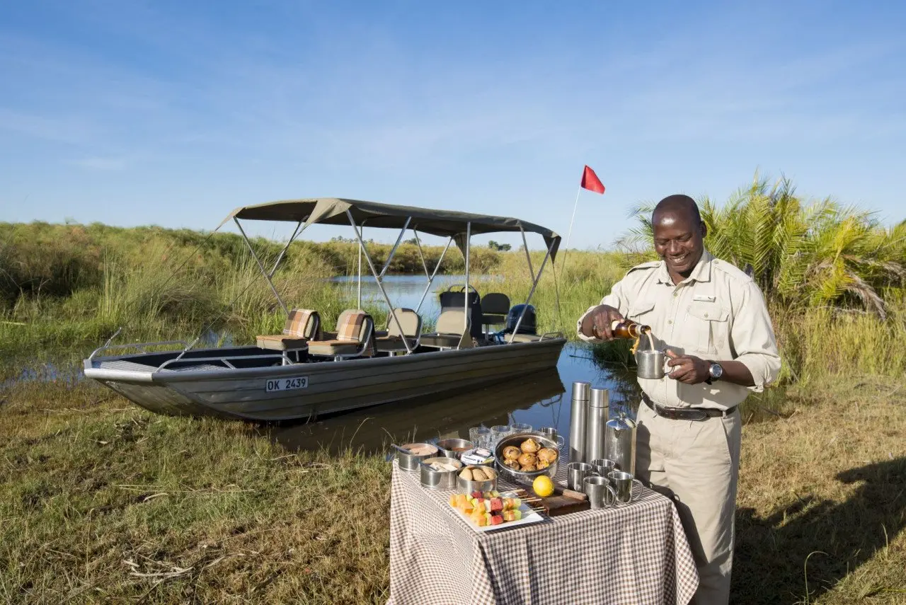 Botswana-Nxabega-Okavango-Tented-Camp-Guest-Delight-butler-setting-up-drinks-after-boat-ride